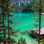 a house on a dock surrounded by trees and mountains