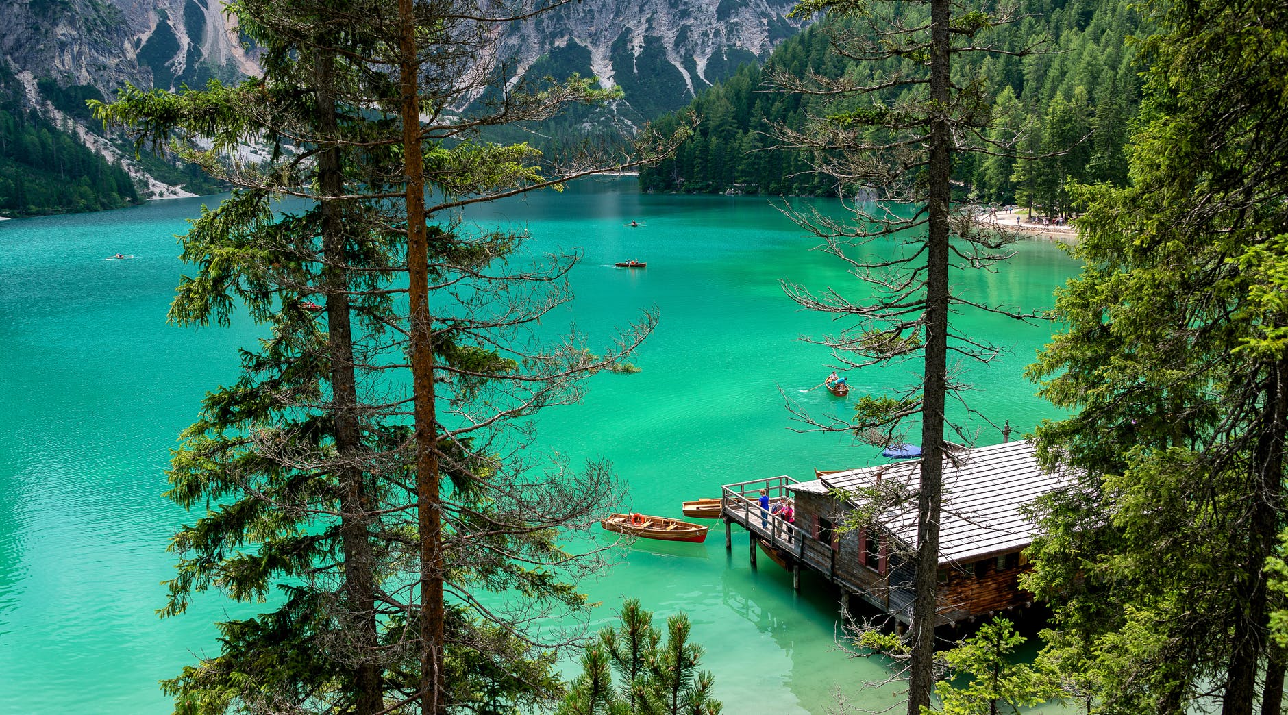 a house on a dock surrounded by trees and mountains