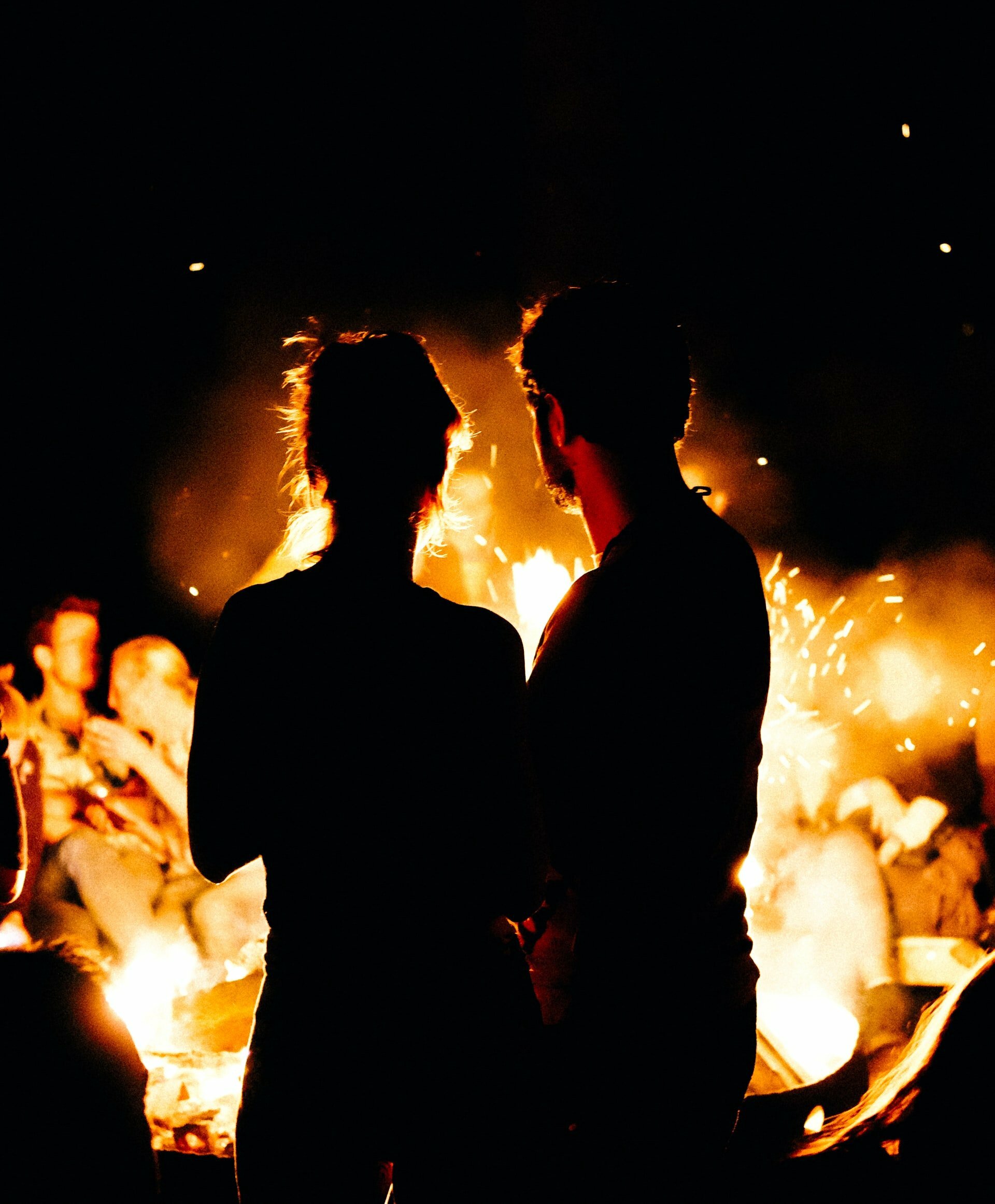 a group of people standing in front of a fire