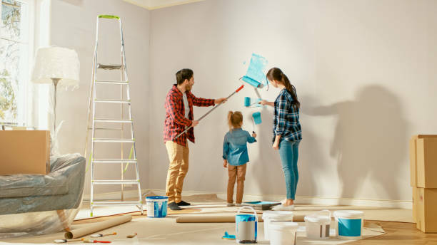 a man and woman painting a room