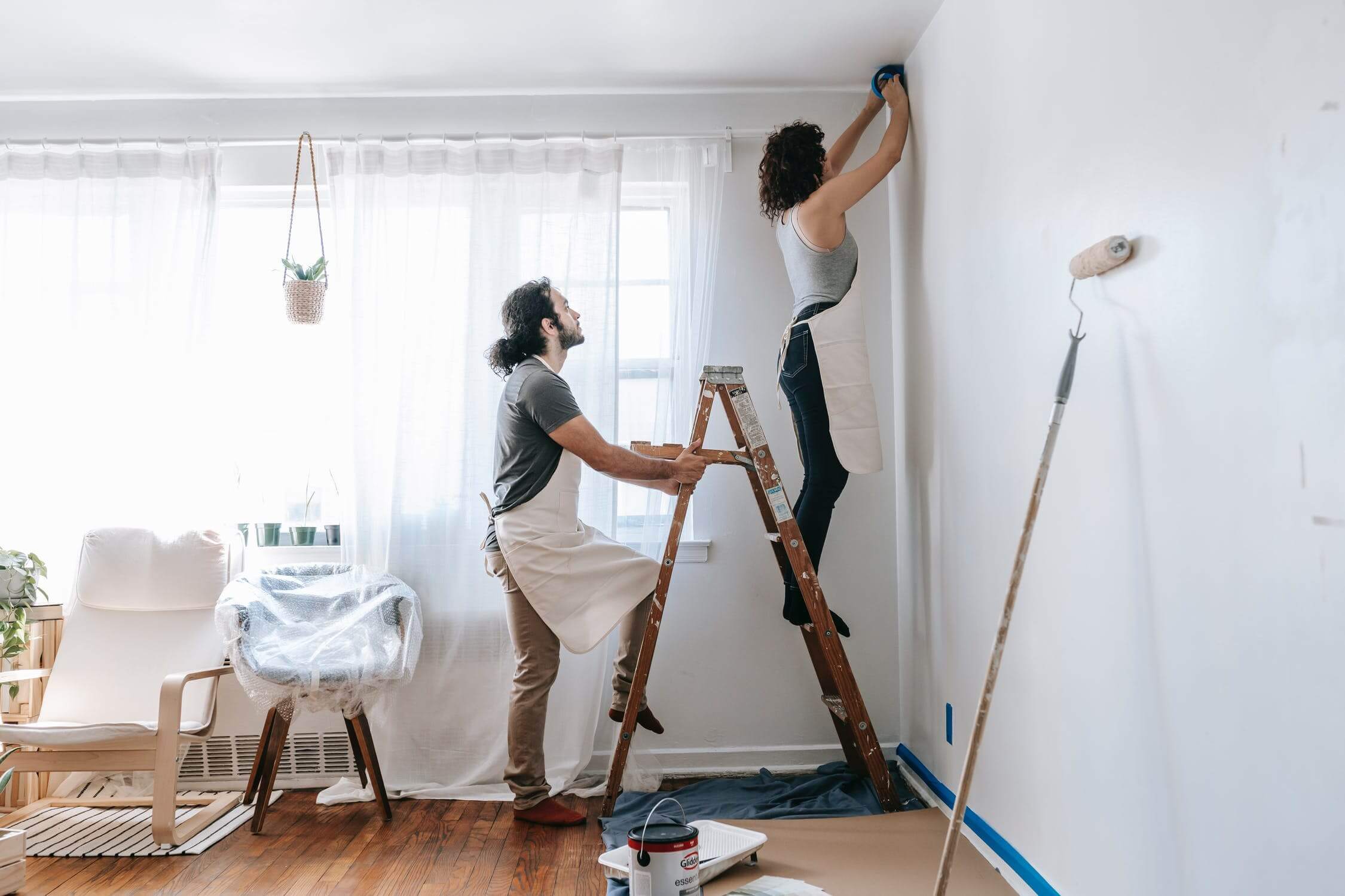 a man and woman painting a room