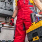 a person in a red suit working on a car