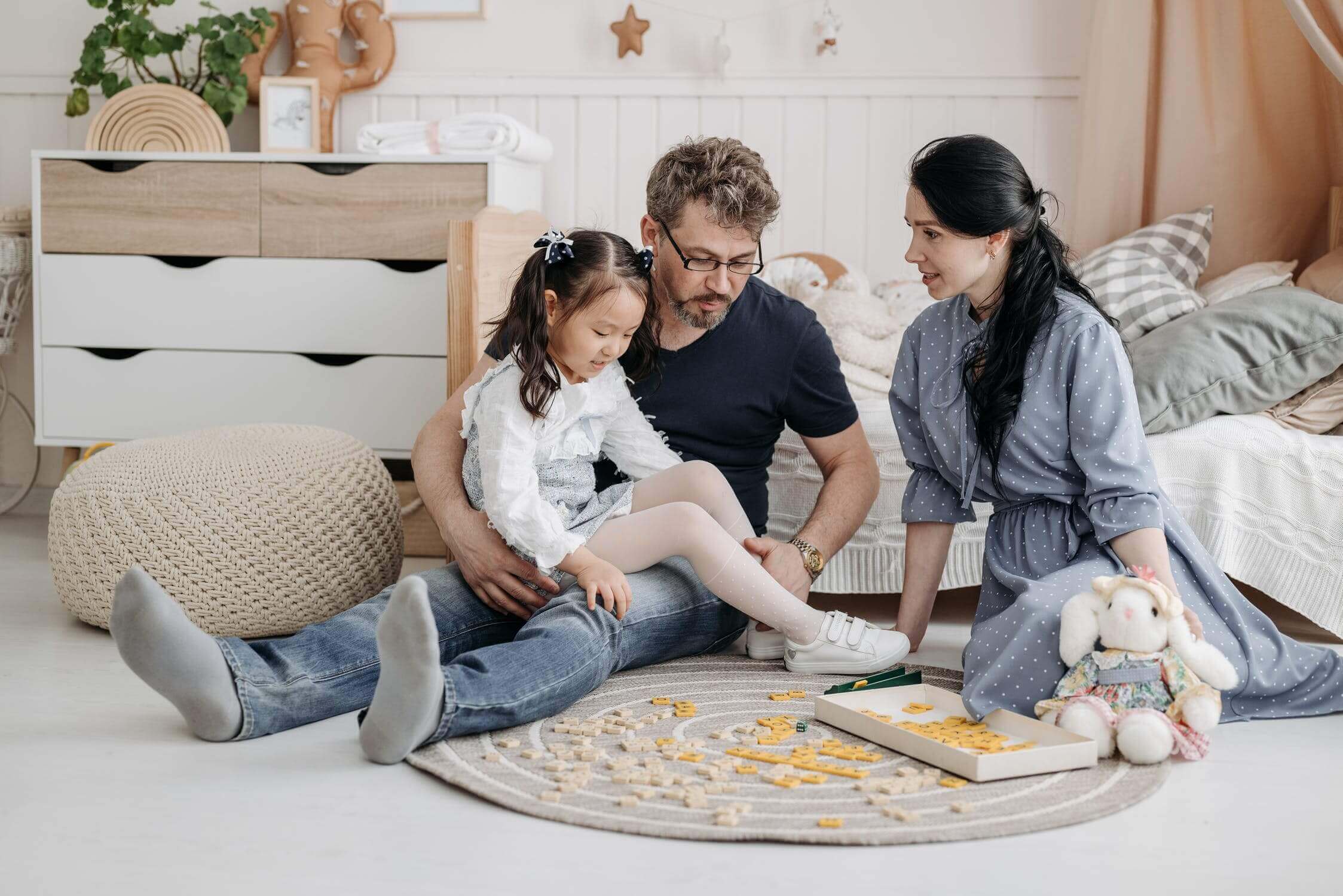 a family sitting on the floor playing a board game