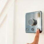a hand holding a silver camera
