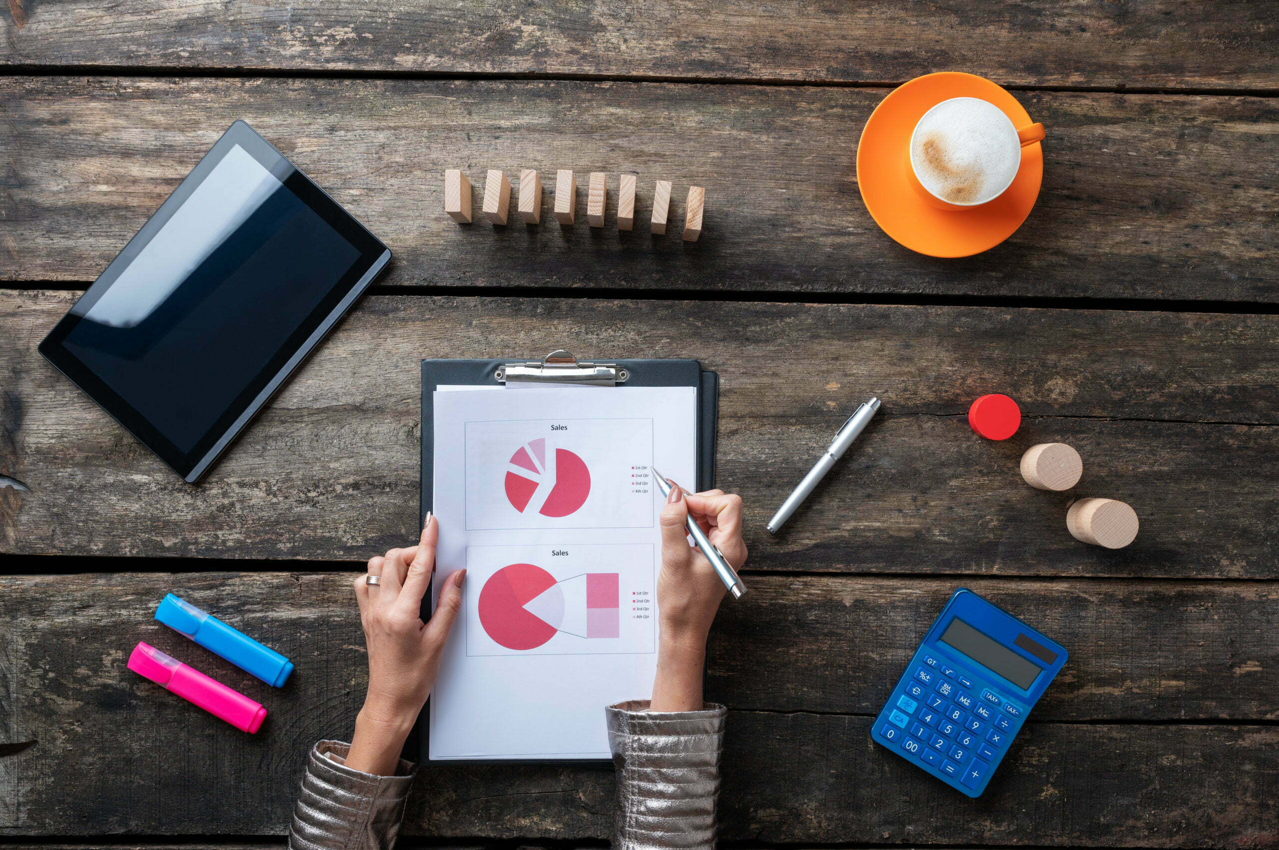 Top view of female accountant working on a document with pie charts